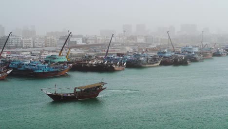 Dhow-Fishing-Boat-Turns-To-PArk-At-Crowded-Port-In-Dubai-Creek-In-The-Morning-In-Dubai,-UAE