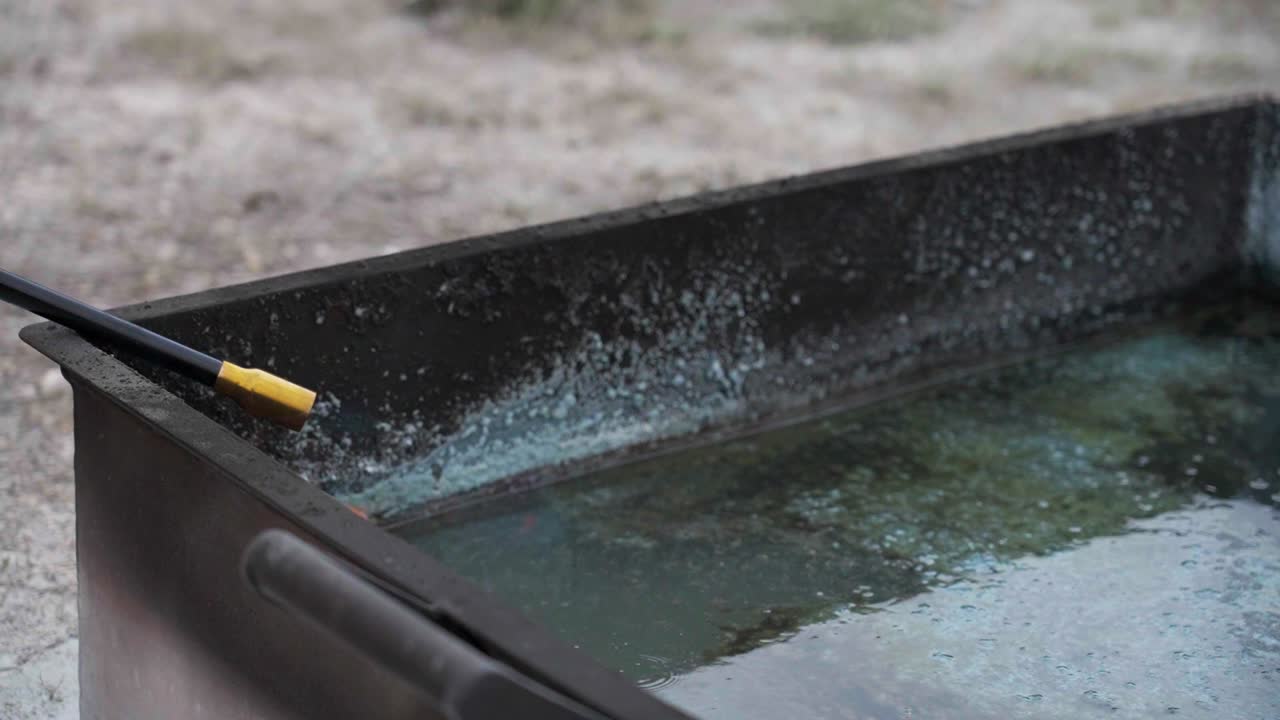 Fire being ignited in a metal container, showing the start of controlled flames outdoors