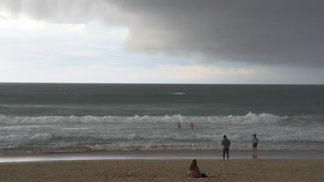 dos hombres jugando en el mar, salpicando el agua con olas rápidas y vigorosas que se estrellan en un día tormentoso, arriesgando su vida en condiciones climáticas salvajes y severas
