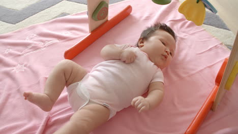 baby girl laying on pink blanket shot in slow motion