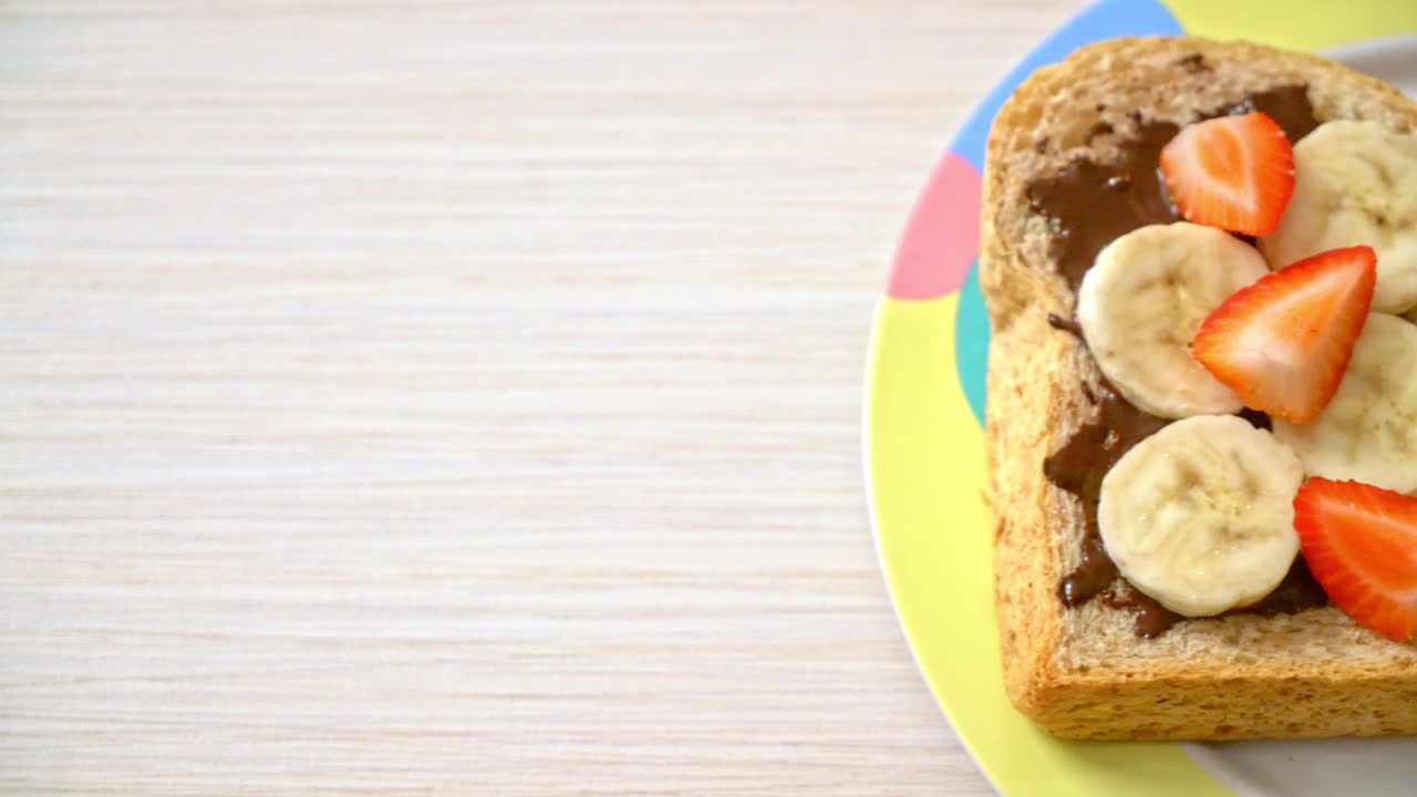 pan integral tostado con plátano fresco, fresa y chocolate para el desayuno