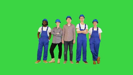 group of construction workers standing with no emotions looking to camera on a green screen, chroma key