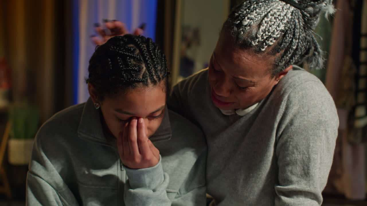 madre consolando a su hija triste