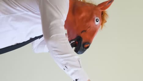 a man in a horse mask dances looking at the camera a man in a horse mask dances looking at the camera