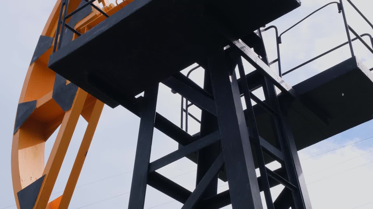 Modern oil rocking chair in a field of green grass. The concept of the cost of a barrel of oil, oil production and processing of raw materials