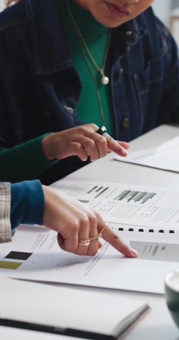 Kolleger gennemgår forretningsrapporter og datadiagrammer på kontoret