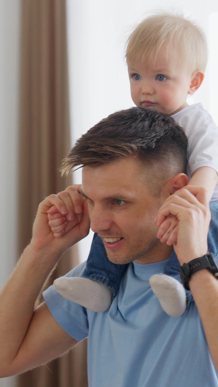Padre felice che porta il figlio piccolo sulle spalle