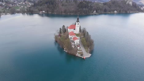 charming autumn panorama landscape of island with church rounded colorful trees in the middle of bled lake