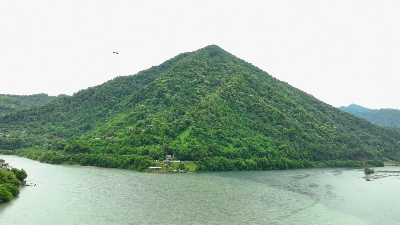 A stunning view of a winding lake bordered by forest-covered hills, illustrating the tranquil and untouched nature of the Georgian landscape