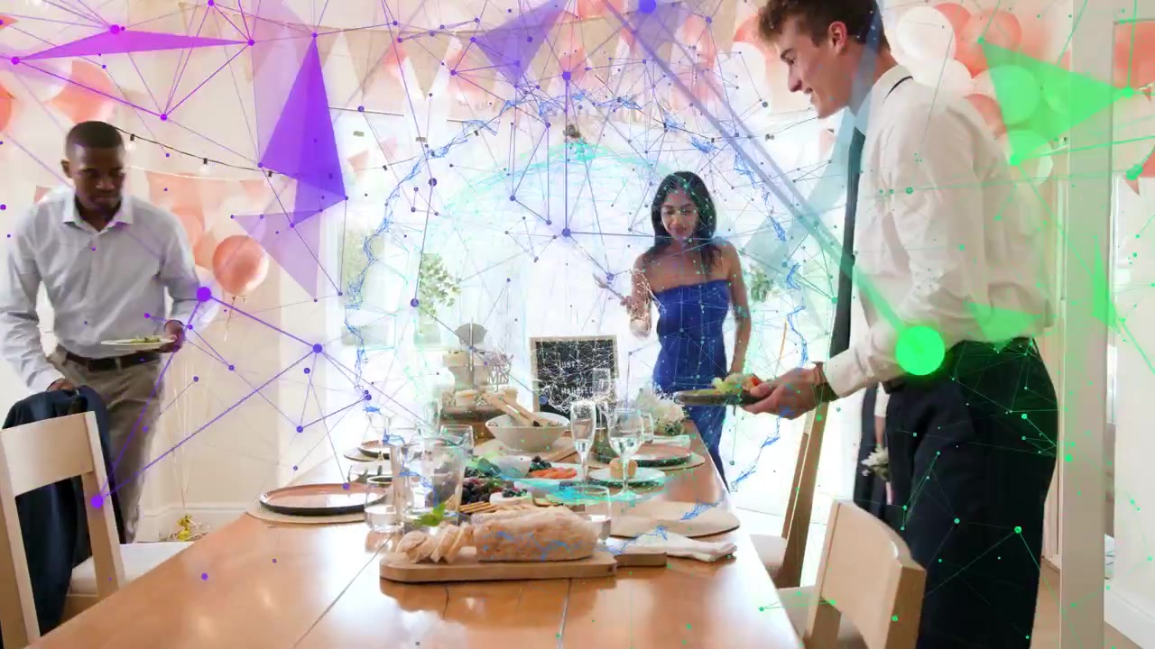 Three adults approaching table, pulling chairs and arranging plates, glasses and platters for event