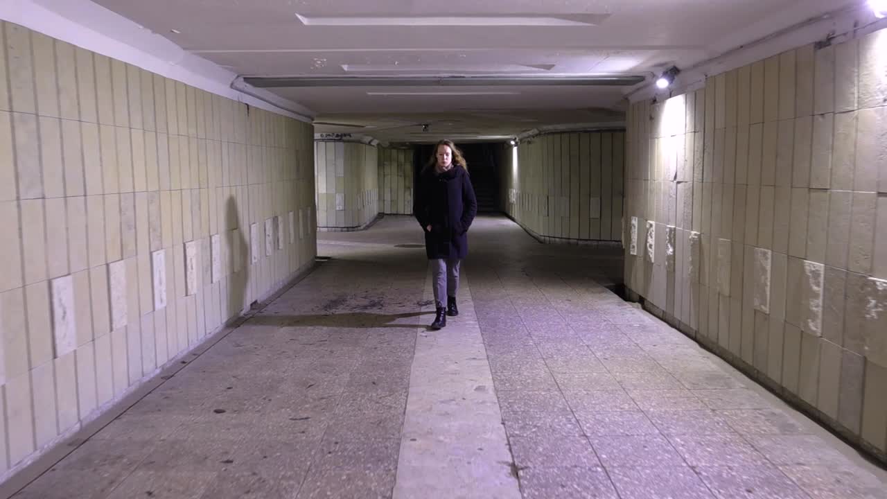 Girl walking in the underground passage at night