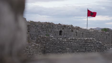 stone castle with waving albanian flag, serene historic atmosphere