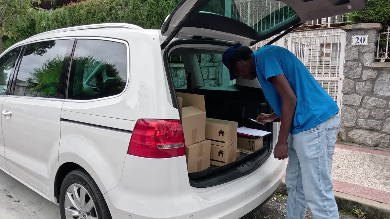Corriere che carica pacchi nel bagagliaio dell'auto