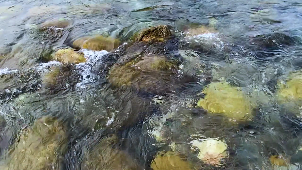 Crystal clear water stream passing across rocky riverbed at Sylhet, Bangladesh. rotating shot
