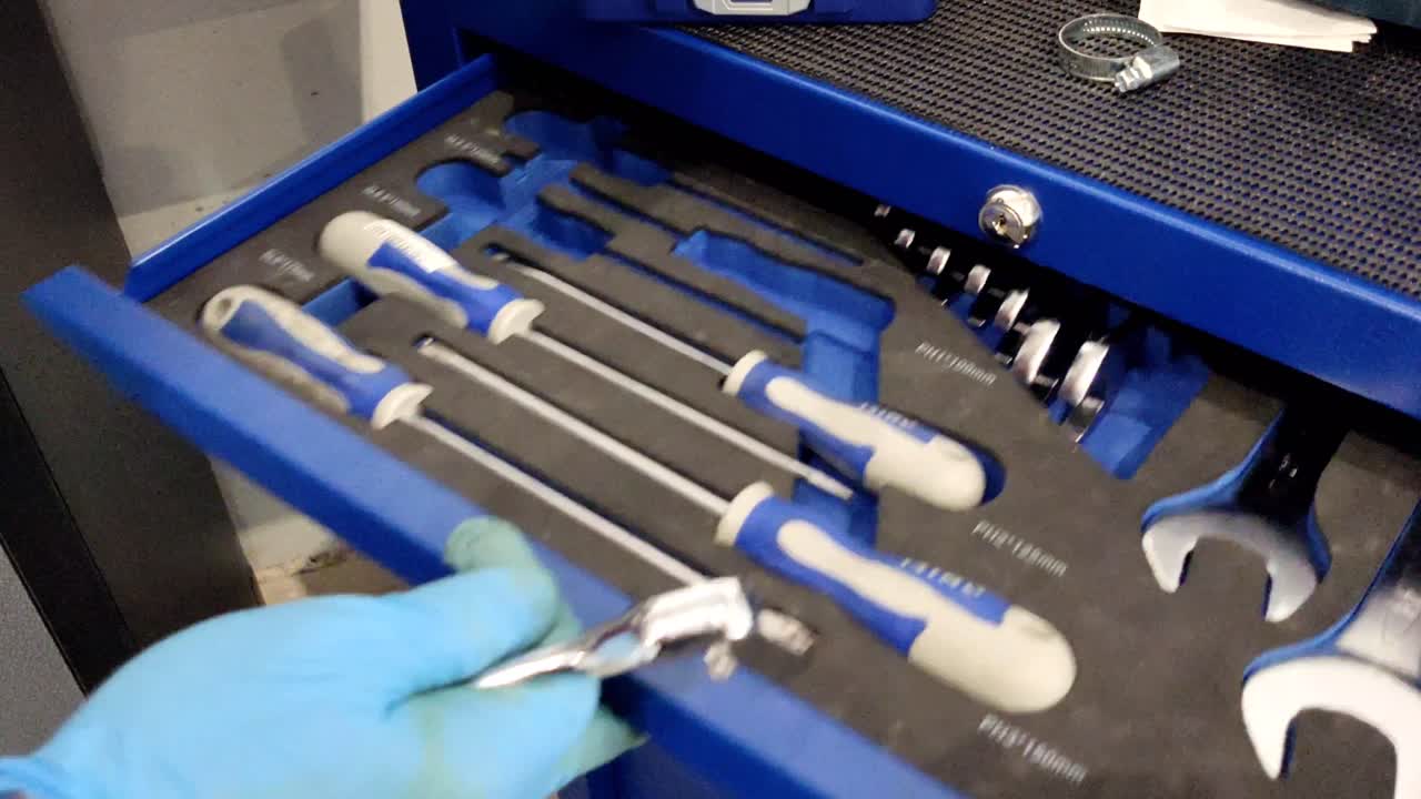 남자의 손은 모바일 워크벤치 워크 ⁇  도구 로커에  ⁇ 키를 다시 넣습니다.