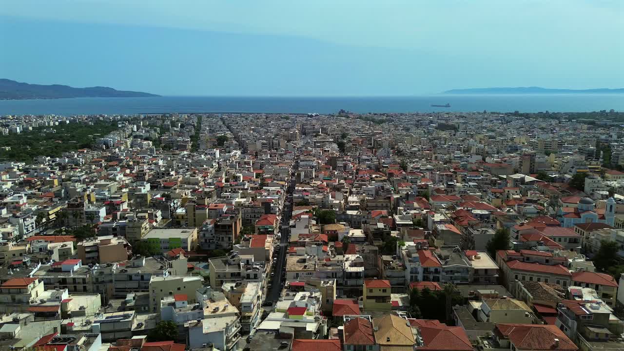 Aerial wide view of cityscape of Kalamata, Messinian bay on background , as seen from historical city center. Push out, right pan drone move 4K
