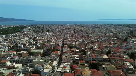 aerial wide view of cityscape of kalamata, messinian bay on background , as seen from historical city center. push out, right pan drone move 4k