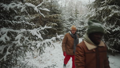 young tourists walking through winter woods