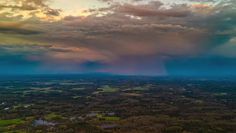 aerial time-lapse of torrential rain moving over rural fields, stormy evening