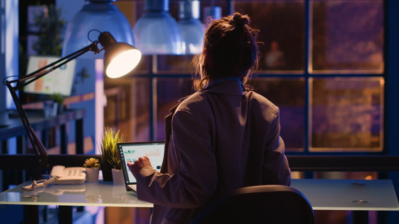 mujer trabajando hasta tarde en la oficina