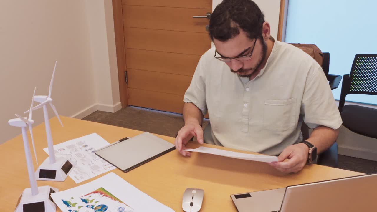 Middle Eastern Engineer Explaining a Design Point on a Blueprint