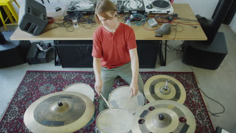 young man playing drums in a studio