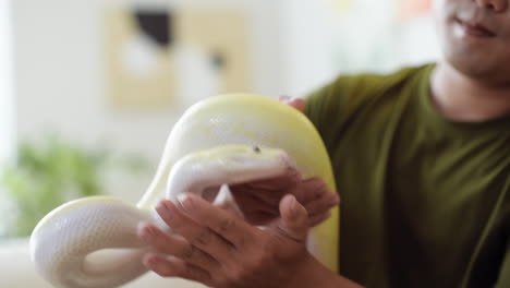 man holding snake indoors