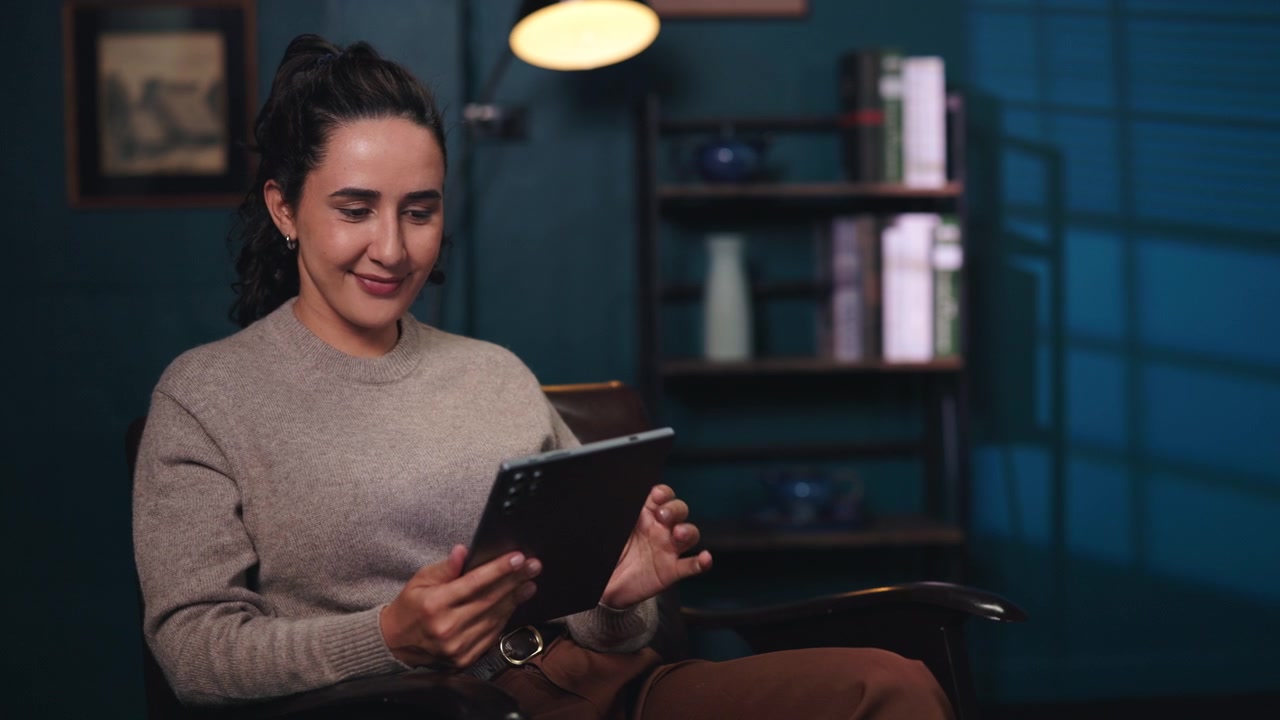 Young Woman Using a Tablet in a Cozy Dimly Lit Room