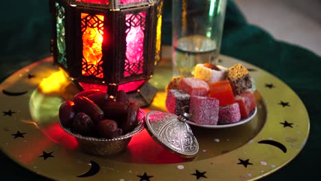 the food of ramadan. glass of water, dates, dried fruits, sweets. a man eats dates to break the fast