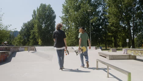 caucasian friends walking in skatepark.