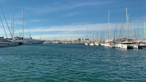 navigation channel with docks full of sailboats and yachts in the port of valencia, spain