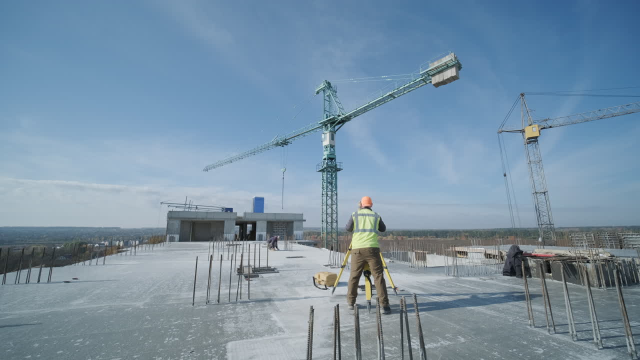 строительная площадка с геодезистом на крыше