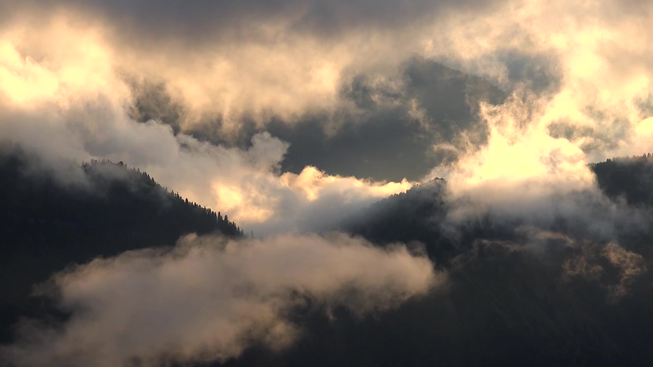 Golden Clouds Drifting Over Mountain Peaks at Sunset