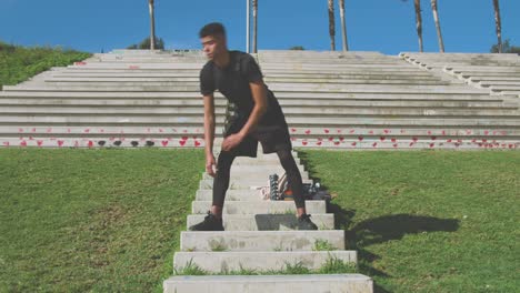 atleta negro calentándose en la parte superior de los escalones