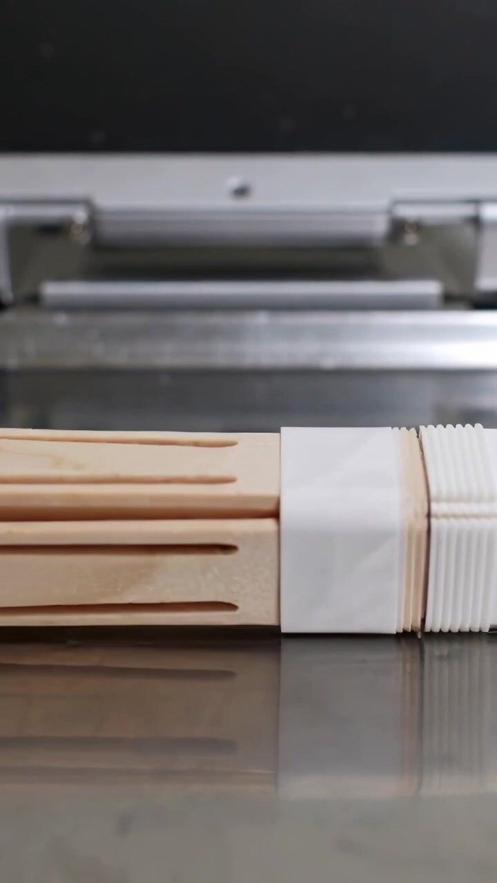 Vertical video: Camera starting nudging wooden chopsticks shifting on steel counter, showing band