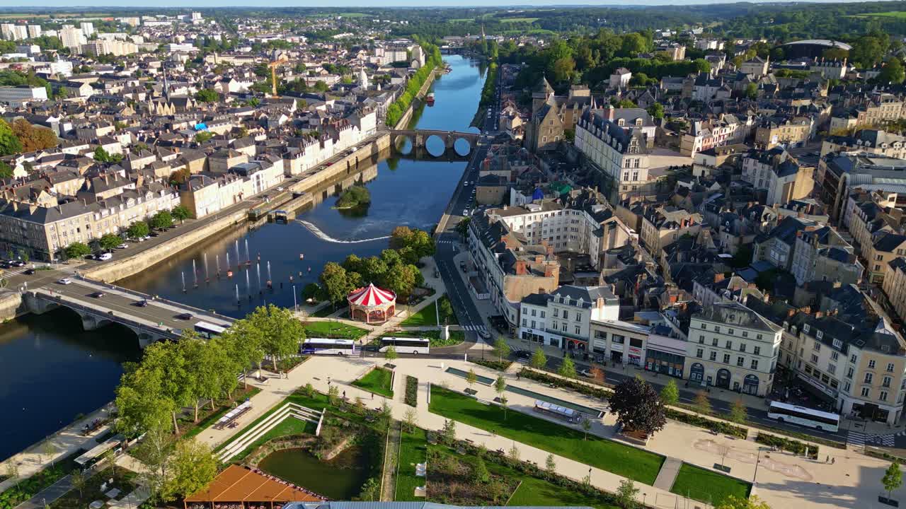 Drone sobrevoa o centro da cidade de Laval, mostrando o rio Mayenne, pontes e arquitetura iluminada pelo sol