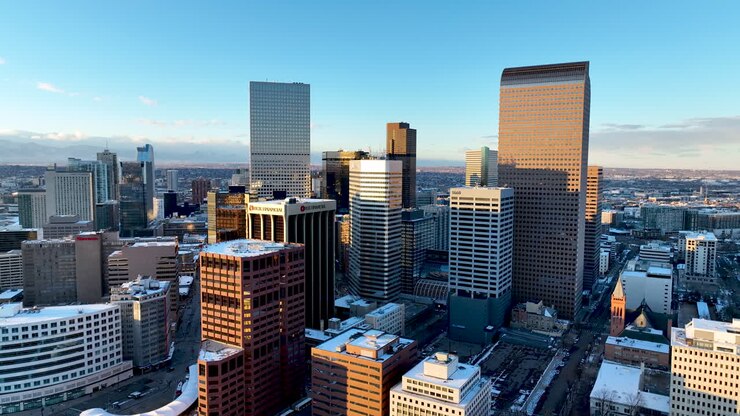 Skyscrapers of Denver CBD highlighted by winter sunset, slow aerial arc