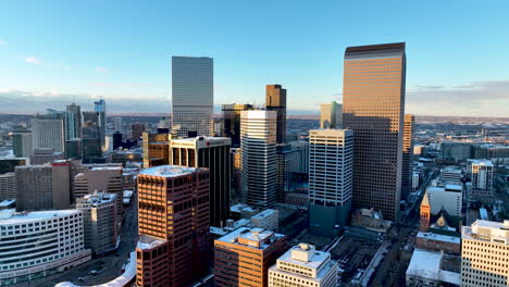 Skyscrapers-of-Denver-CBD-highlighted-by-winter-sunset,-slow-aerial-arc