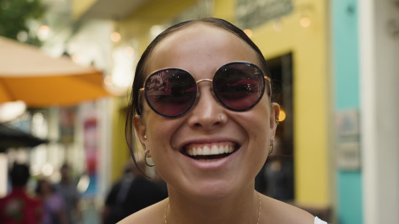 cámara lenta de primer plano de una modelo sonriendo y riendo en las calles de san juan