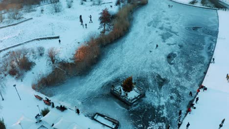 aerial view of people on frozen lake ice skating on cold winter day, utrecht, netherlands