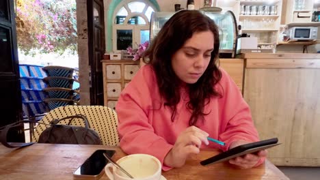 young woman concentrating on her digital work at a coffee shop