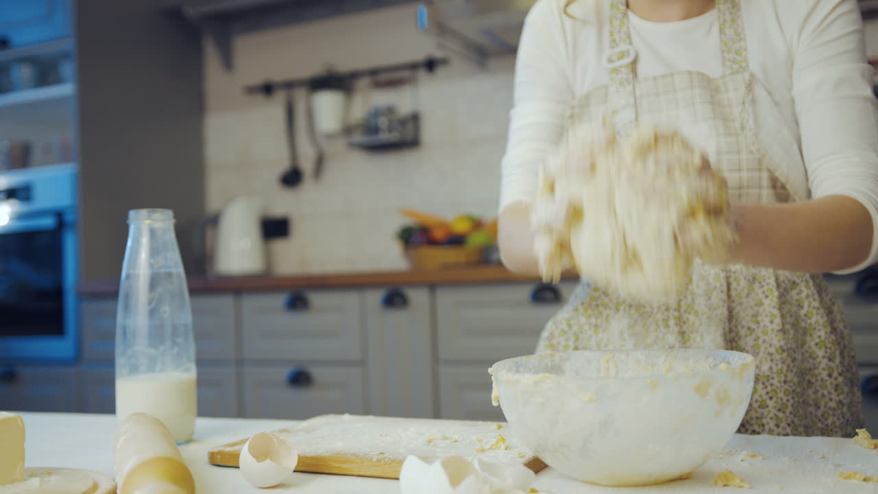 primer plano de la joven mujer caucásica amasando una daugh en un tazón de vidrio en la acogedora cocina moderna. retrato. interior