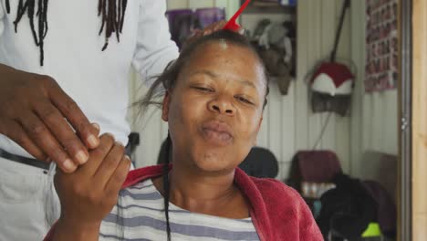 african woman having her hair styled