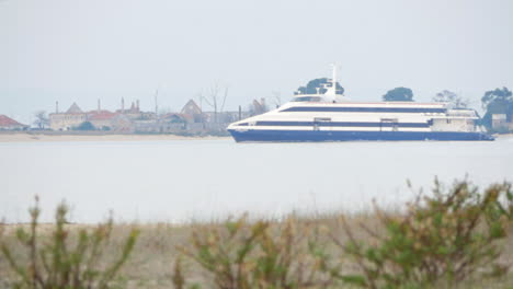 passenger boat cruising on river on a foggy morning from riverside