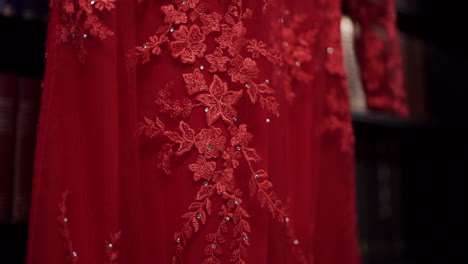 close-up of intricate floral lace detailing on a red fabric, showcasing elegant craftsmanship