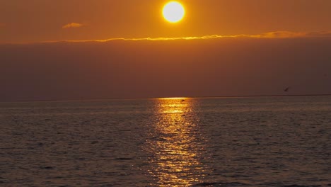 dramatic, beautiful, epic red and orange sunset in the ocean, wide shot tilt up