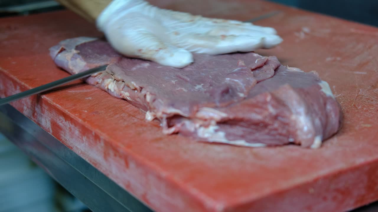 tagliare una bistecca cruda con un coltello da vicino