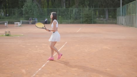 beautiful tennis girl practicing serve on outdoor court