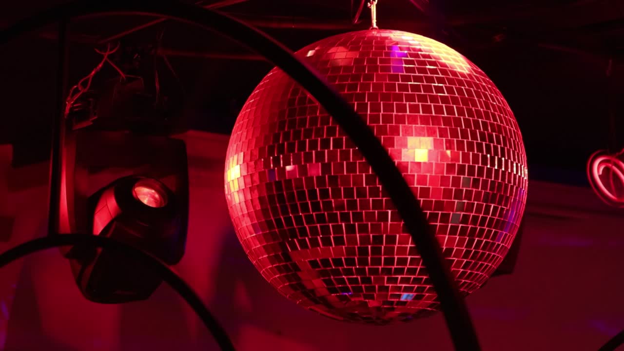 Sfondo con riflessi di luce da palla da discoteca in un locale notturno.