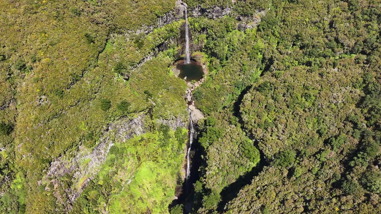 Drone pullback reveals scenic Risco falls in lush landscape of Madeira